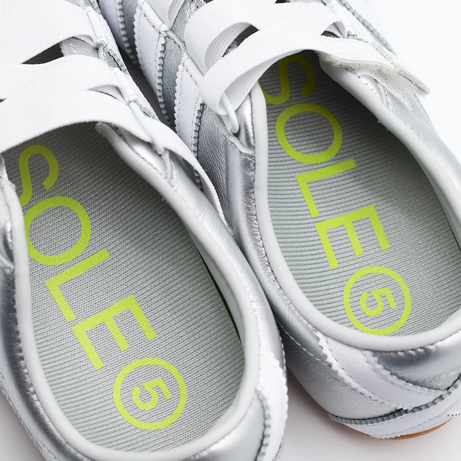 Extreme close up image of a pair of Half Length Orthotic Insoles fitted inside a silver coloured casual shoe
