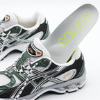 Green and white running shoe with a SOLE5 Orthotic Insole being placed into it