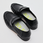 A close up photo of a pair of loafers with a pair of SOLE5 Half Length Orthotic Insoles fitted inside