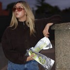 Person holding two SOLE5 packages, standing against a dark background.