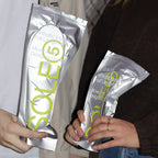 Two people holding SOLE5 packages with a focus on the product.