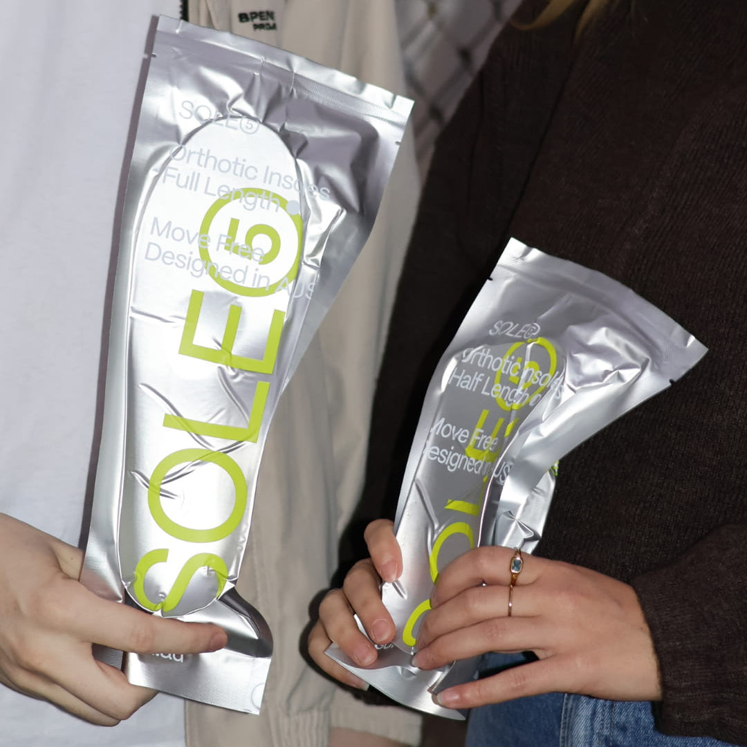 Two people holding SOLE5 packages with a focus on the product.