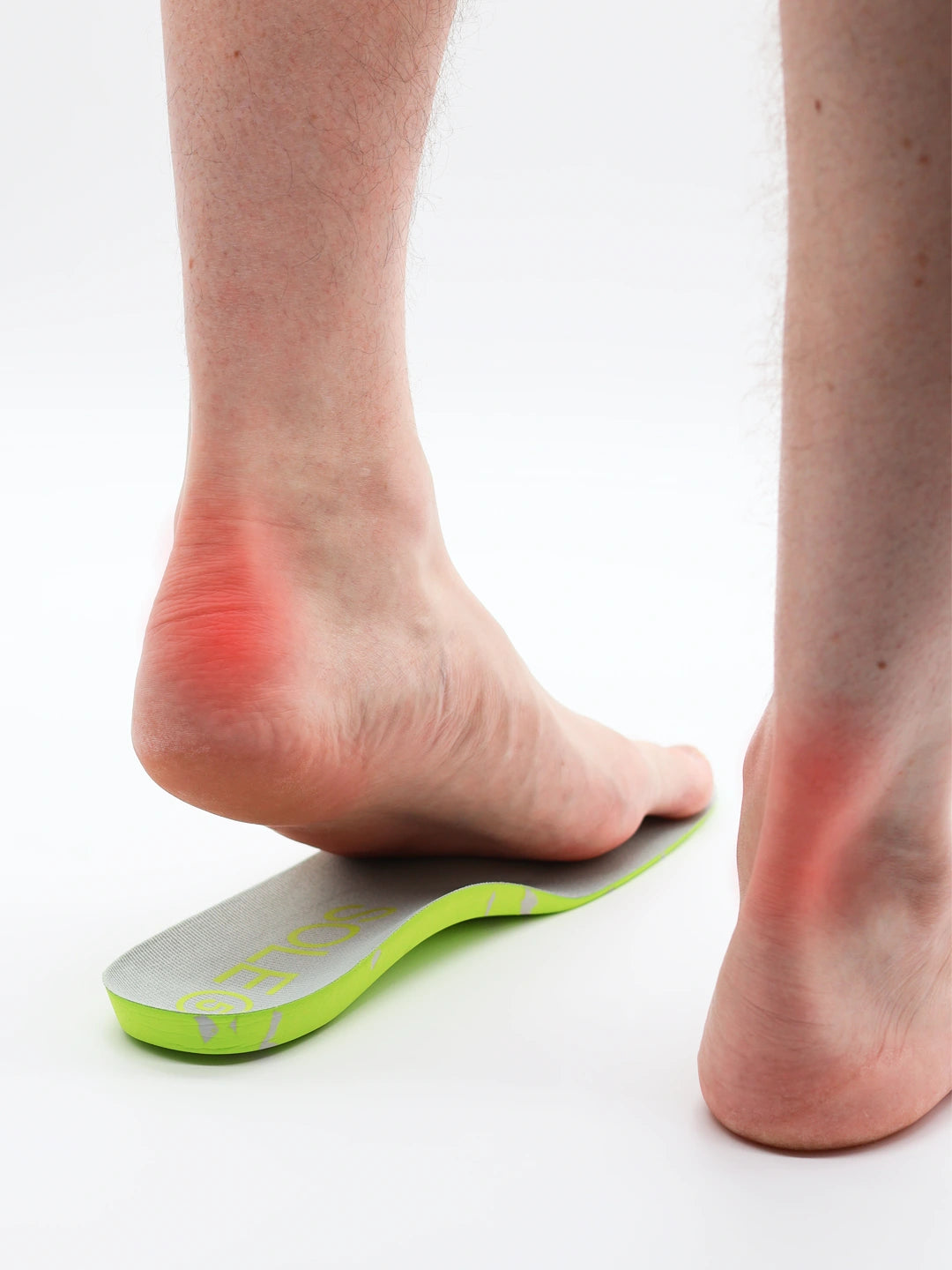 Person wearing a SOLE5 orthotic insole with red area indicating Achilles tendonitis pain on a white background