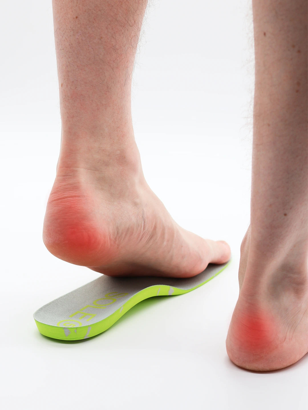 Person wearing a SOLE5 orthotic with red indicating heel pain points on a white background