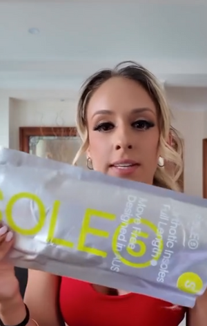 Video of a girl in activewear opening SOLE5 packaging