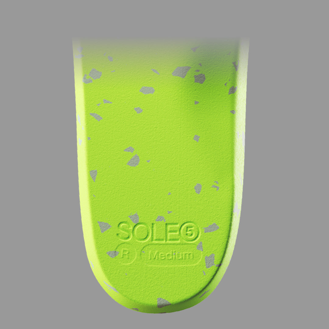 Close up of underneath of SOLE5 Orthotic Insole highlighting the shock absorbing material on grey background
